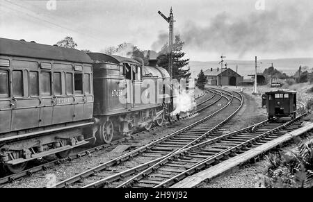 L'immagine da un negativo monocromatico scansionato è alla stazione ferroviaria di Reedsmouth nel North Yorkshire come era nel mese di ottobre 1956 con il treno a vapore pannier passeggero 67639 che esce dalla stazione Foto Stock