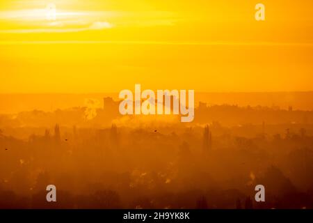 Alba invernale con il castello di Windsor che emerge dalla nebbia all'orizzonte Foto Stock