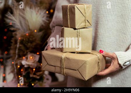 Presente avvolto in carta tenuto in mano del woman. Buon Natale e felice anno nuovo concetto Foto Stock