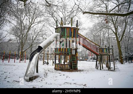 Berlino, Germania. 09th Dic 2021. Un parco giochi vuoto al Rudolph Wilde Park di Berlino è coperto da un leggero strato di neve. La neve è caduta nella capitale giovedì (dicembre 9, 2021). Credit: Stella Venohr/dpa/Alamy Live News Foto Stock