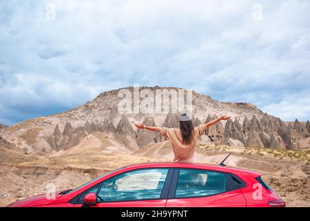 Donna felice in vacanza estiva in luogo famoso. Formazioni cave. Foto Stock