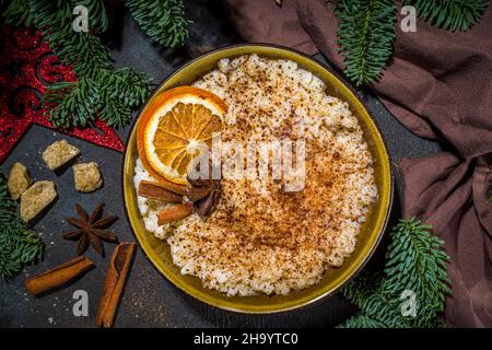 Risgryngrot, porridge di riso di Natale in stile scandinavo con cannella e spezie, con decorazioni a rami di albero di Natale Foto Stock