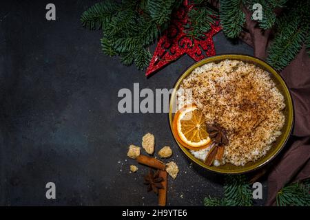 Risgryngrot, porridge di riso di Natale in stile scandinavo con cannella e spezie, con decorazioni a rami di albero di Natale Foto Stock