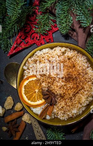 Risgryngrot, porridge di riso di Natale in stile scandinavo con cannella e spezie, con decorazioni a rami di albero di Natale Foto Stock