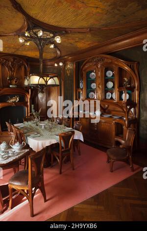 Sala da pranzo Art Nouveau progettata dal designer francese Eugène Vallin (1903-1906) in mostra nel Museo della Scuola di Nancy (Musée de l'École de Nancy) a Nancy, Francia. I pannelli del soffitto Art Nouveau e le decorazioni in pelle sono stati progettati in collaborazione con l'artista francese Victor Prouvé. Questo set di mobili è stato commissionato dall'uomo d'affari francese Charles Masson per il suo appartamento a Nancy. Foto Stock