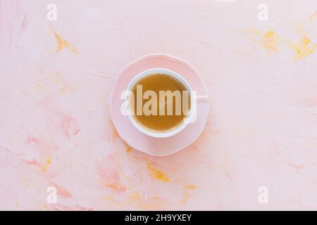 Caffè espresso in tazza di porcellana su sfondo rosa pastello. Layout piatto, vista dall'alto, spazio di copia Foto Stock