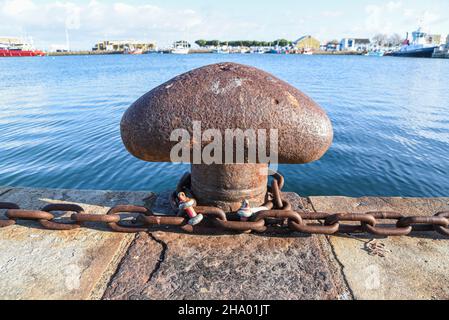 Grande vecchio arrugginito barca ormeggio pali nel porto. Foto Stock