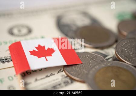 Bandiera canadese su monete e banconote background, finanza e contabilità, concetto bancario. Foto Stock