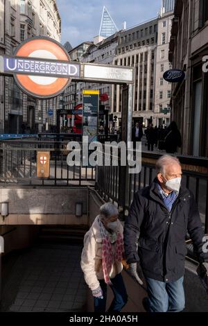 La mattina dopo che il primo ministro Boris Johnson ha annunciato il piano B del suo governo, un nuovo insieme di restrizioni Covid diretto a rallentare la diffusione della variante di Omicron, una coppia emerge dalla stazione della metropolitana Monument nella città di Londra, il distretto finanziario della capitale, Che negli ultimi mesi è diventato molto più affollato quando i lavoratori sono tornati ai loro uffici dopo aver lavorato da casa, il 9th dicembre 2021, a Londra, Inghilterra. Il piano B include la regola secondo cui i lavoratori dovrebbero lavorare ancora una volta da casa, se possibile, a partire da lunedì prossimo, 13th dicembre. Foto Stock