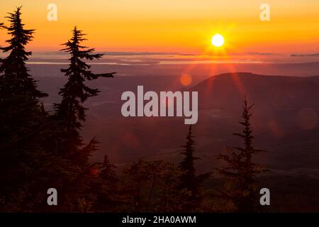 WA19860-00...WASHINGTON - Sole che si staglia attraverso un cielo pieno di fumo sopra lo stretto di Juan de Fuca e le Lowlands Puget Sound Foto Stock
