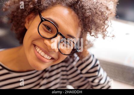 Una donna allegra e multietnica esprime emozioni positive Foto Stock