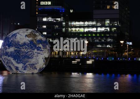 Evento delle onde leggere di Media City con installazione Floating Globe nell'edificio della BBC Salford Quays con tram Metrolink. Esposizione prolungata. Manchester Regno Unito Foto Stock