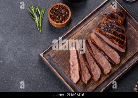 Bistecca di Chuck eye roll cotta alla griglia su un tagliere. Sfondo scuro Foto Stock