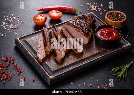 Bistecca di Chuck eye roll cotta alla griglia su un tagliere. Sfondo scuro Foto Stock