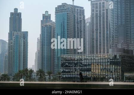 Dubai, Emirati Arabi Uniti. 8th Nov 2021. Un uomo cammina su un tetto con grattacieli residenziali e commerciali nel quartiere del centro di Dubai sullo sfondo. (Credit Image: © Omar Marques/SOPA Images via ZUMA Press Wire) Foto Stock