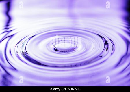 spruzzi di acqua goccia su acqua base calma Foto Stock