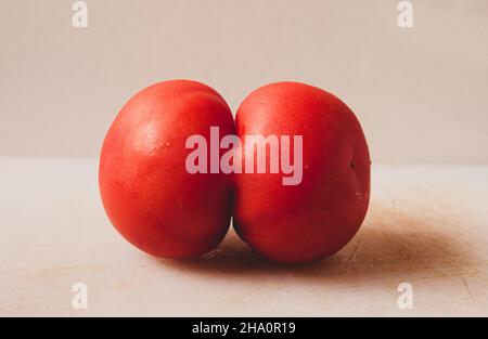 due pomodori uniti in uno Foto Stock