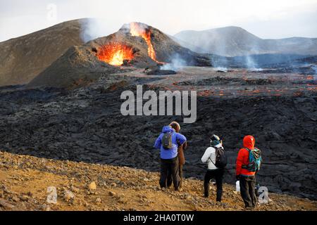 la gente osserva la caldera del vulcano e la lava Foto Stock