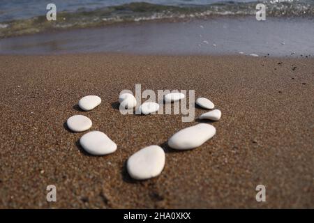 Pietre a forma di cuore su una spiaggia di Cipro con le onde dietro di essa Foto Stock