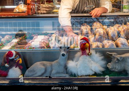 Vetrata in un macellaio a Natale con fagiani in vendita e graziose decorazioni animali di Natale, Alresford, Hampshire, Inghilterra, Regno Unito Foto Stock