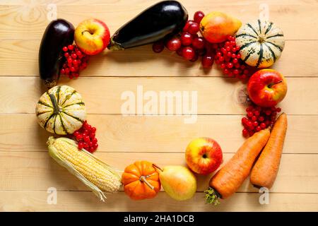 Cornice fatta di cibo sano diverso su sfondo di legno. Festa del raccolto Foto Stock