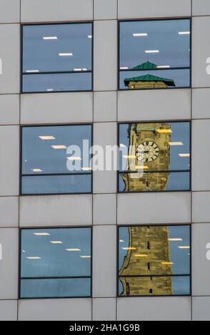 Riflesso della Civic Center Clock Tower nelle finestre di un edificio di uffici nel centro della città di Southampton, Hampshire, Inghilterra, Regno Unito Foto Stock