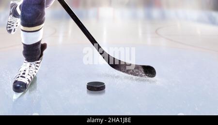 Vista ad angolo basso del giocatore di hockey su ghiaccio con bastone sulla pista di ghiaccio che controlla il puck e lo spazio di copia. Foto Stock