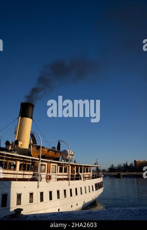 Inquinamento atmosferico a Stoccolma. Camino di barca con fumo nero che esce da esso. Tema del cambiamento climatico e delle emissioni di carbonio. Foto Stock