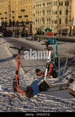 Scooter elettrici sulla neve. Trasporto ecologico e pendolarismo in inverno. Su calce Plus Uber. Stoccolma, Svezia Foto Stock