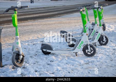 Scooter elettrici sulla neve. Trasporto ecologico e pendolarismo in inverno. Su calce Plus Uber. Stoccolma, Svezia Foto Stock