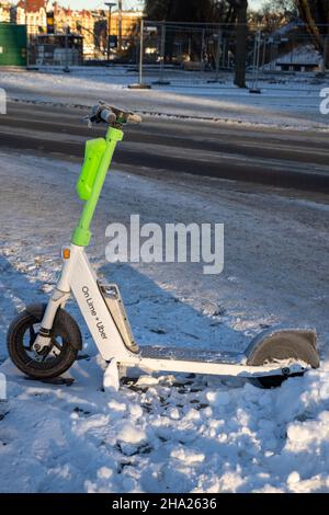 Scooter elettrici sulla neve. Trasporto ecologico e pendolarismo in inverno. Su calce Plus Uber. Stoccolma, Svezia Foto Stock