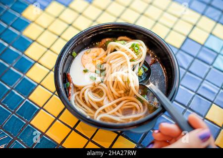 Zuppa orientale asiatico ramen con noodles e mezzo di un uovo in fast food cafe Foto Stock