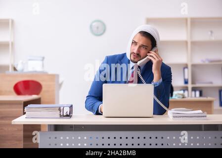 Giovane impiegato di uomini d'affari che soffre di mal di denti sul posto di lavoro Foto Stock