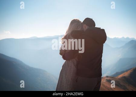 Giovane coppia felice che ha una pausa durante un viaggio escursionistico in montagna Foto Stock
