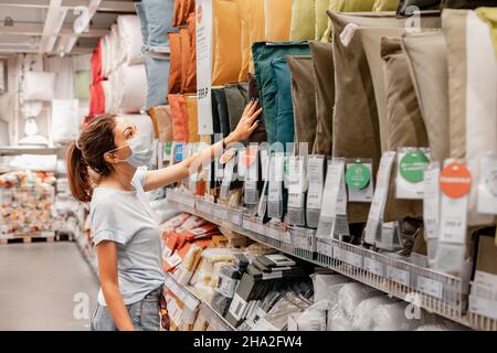 14 giugno 2021, Ufa, Russia: La donna in maschera shopping per cuscini e cuscini in un negozio IKEA Foto Stock