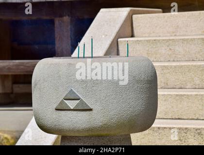 Primo piano dell'incenso che brucia di fronte ad una scala Foto Stock