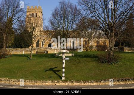 Village Green, Earls Barton, Northaptonshire, Regno Unito; sullo sfondo l'iconica chiesa sassone di tutti i Santi Foto Stock