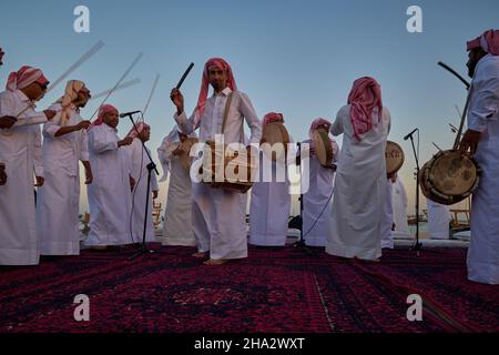 Danza folcloristica tradizionale del Qatar (danza Ardah) a Katara undicesimo festival dhow tradizionale a Doha Qatar tramonto sparato Foto Stock