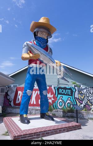 Tulsa, Oklahoma, il curio cosmico di Buck Adam- l'uomo di Muffler che tiene un razzo Foto Stock