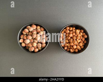 Nocciole, nocciole in abwl con fondo nero. Concetto e idea del cibo. Foto Stock