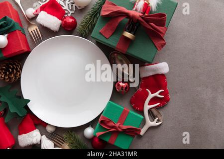 Cena natalizia di sottofondo. Piatto bianco vuoto con decorazioni natalizie Foto Stock