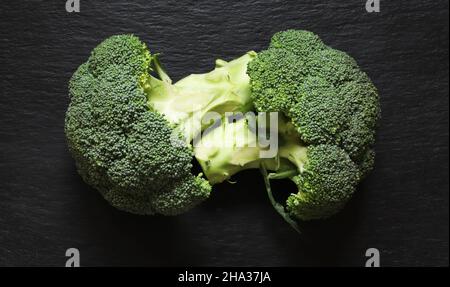 Vista dall'alto di due grappoli testa a coda di broccoli in ardesia Foto Stock