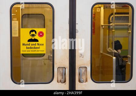 Monaco di Baviera, Germania. 10th Dic 2021. Un adesivo che indica 'coprire la bocca e il naso!' viene visualizzato su un treno della metropolitana. Credit: Sven Hoppe/dpa/Alamy Live News Foto Stock