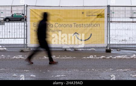 Monaco di Baviera, Germania. 10th Dic 2021. Un uomo passa davanti a un poster sul Theresienwiese che recita 'ingresso Corona Test Station'. Credit: Sven Hoppe/dpa/Alamy Live News Foto Stock