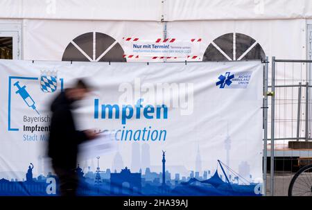 Monaco di Baviera, Germania. 10th Dic 2021. Un uomo cammina davanti a un poster che legge 'vaccinare' sul Theresienwiese. Credit: Sven Hoppe/dpa/Alamy Live News Foto Stock