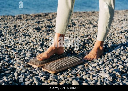 Primo piano di un piede su una tavola con unghie, pratica spirituale di agopuntura e di agupressione. Foto Stock