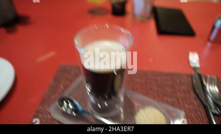 Caffè e un biscotto su un vassoio su un tavolo rosso W Bangkok Foto Stock