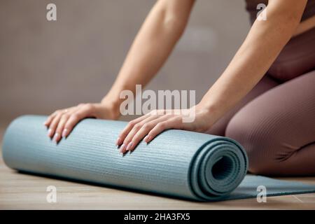 Donna incinta sorridente in abbigliamento sportivo pronto per la ginnastica mattutina o l'esercizio fisico. Giovane donna felice seguire stile di vita sano durante la gravidanza, tenere yoga Foto Stock