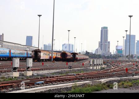 Binari ferroviari vuoti che si dirigono verso la città con cielo blu, paesaggio all'aperto. Foto Stock