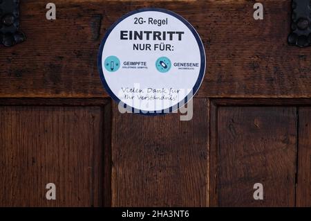 Monaco di Baviera, Germania. 10th Dic 2021. Sulla porta di un ristorante è apposto un adesivo con la dicitura "2G regola, ingresso solo per vaccinati e recuperati". Credit: Sven Hoppe/dpa/Alamy Live News Foto Stock